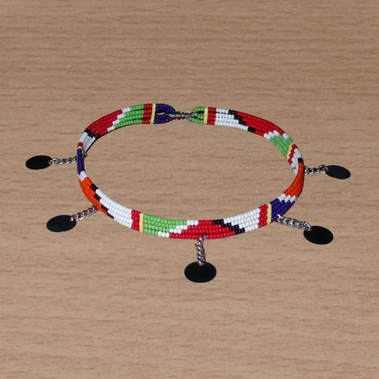 Collier africain à motifs ethniques Massai composé quatre rangées de perles de rocaille rouges, vertes, blanches, orange et bleu foncé, et décoré de cinq disques métalliques attachés à des petites chaînettes. La longueur autour du cou de ce collier est de 34 cm et sa largeur de 1 cm.
