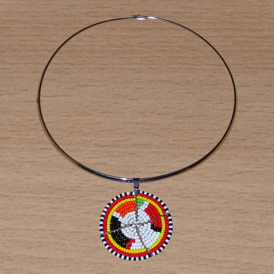 Collier africain composé d'un ras de cou en laiton décoré d'un médaillon Massai fait d'un tissage de perles de rocaille blanches et multicolores.