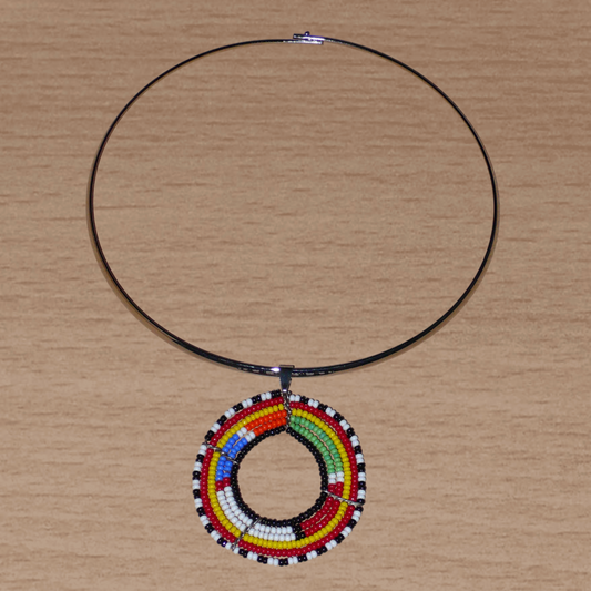Collier africain alliant tradition kenyane et modernité se composant d'un ras de cou en laiton orné d'un médaillon perlé aux couleurs ethniques et motifs traditionnels Massai fait de perles de rocaille multicolores.