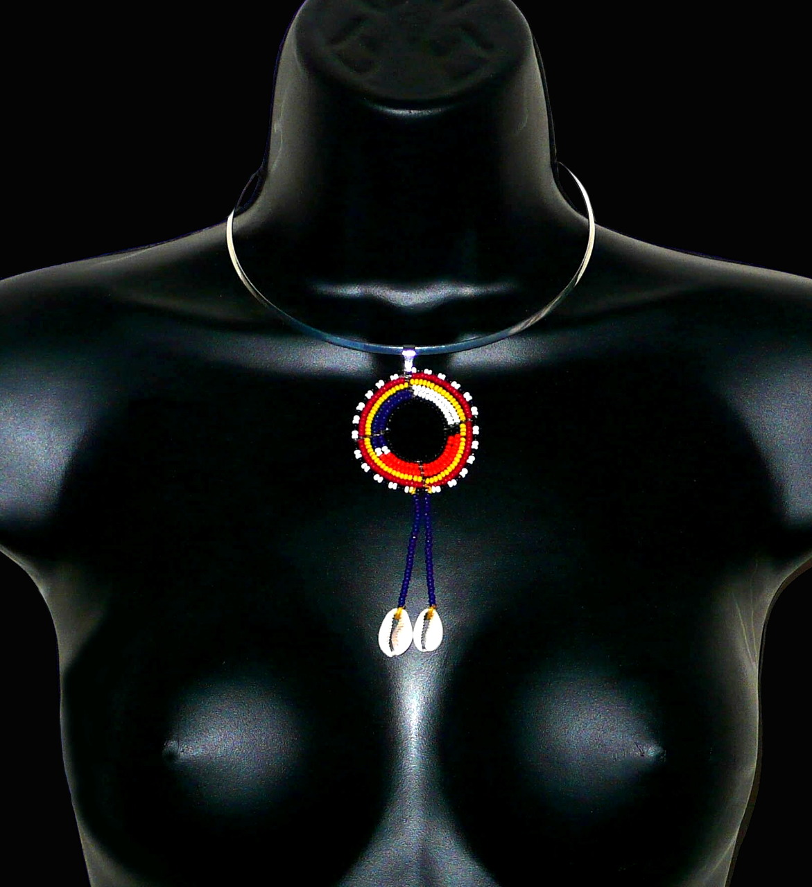 Collier africain Massai composé d'un ras de cou en laiton agrémenté d'un long pendentif ethnique fait de perles de rocaille et de coquillages cauris.