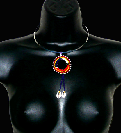 Collier africain Massai composé d'un ras de cou en laiton agrémenté d'un long pendentif ethnique fait de perles de rocaille et de coquillages cauris.
