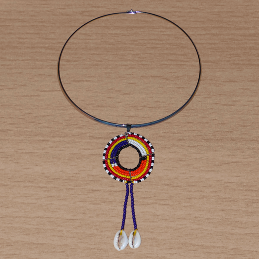 Collier africain Massai composé d'un ras de cou en laiton agrémenté d'un long pendentif ethnique fait de perles de rocaille et de coquillages cauris.