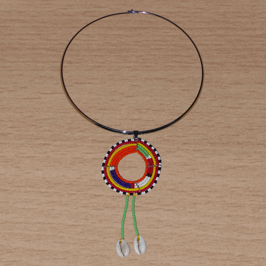 Collier africain se composant d'un ras de cou en laiton orné d'un long pendentif ethnique Massai en perles de rocaille vertes et multicolores et coquillages cauris.