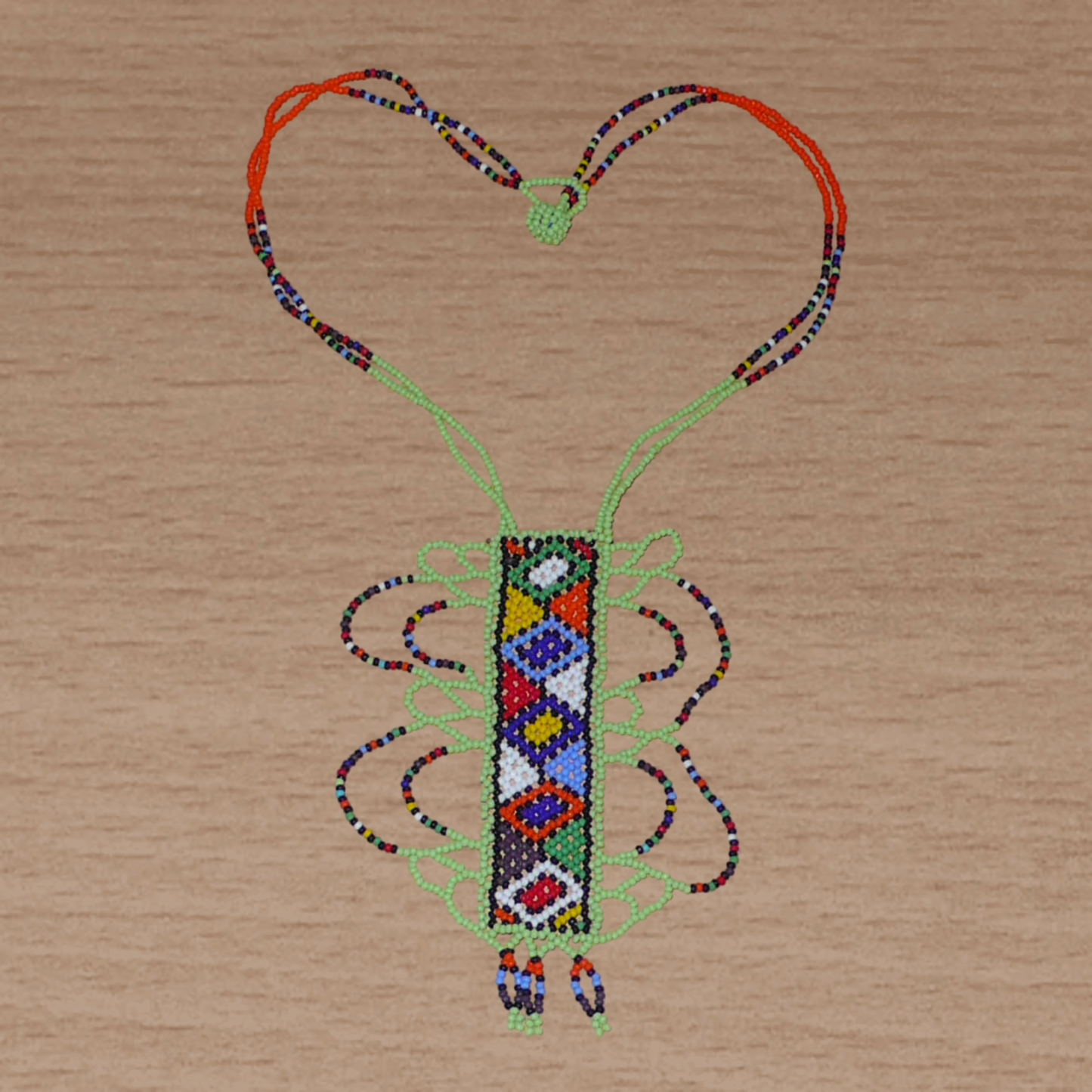 Collier sud-africain vert et multicolore à motifs ethniques zoulous, agrémenté d'un long et large pendentif en perles de rocaille.

