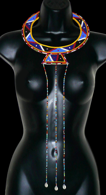 Collier africain traditionnel Massai composé de perles de rocaille principalement bleues brodées sur un morceau de cuir brut ; il se prolonge de longues franges perlées avec à leur base des coquillages cauris.