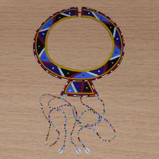 Collier africain traditionnel Massai composé de perles de rocaille principalement bleues brodées sur un morceau de cuir brut ; il se prolonge de longues franges perlées avec à leur base des coquillages cauris.
