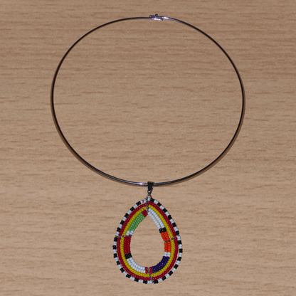 Alliance de tradition Massai et de modernité, ce collier ethnique chic se compose d'un ras de cou en laiton orné d'un pendentif en forme de goutte fait de perles de rocaille multicolores.