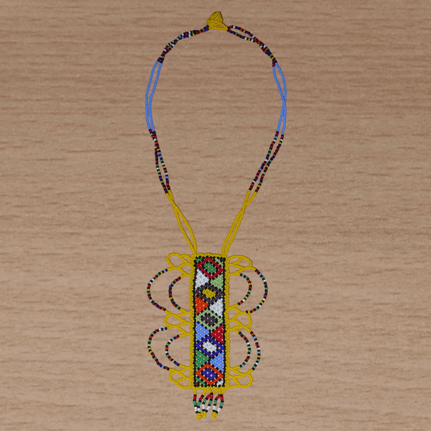 Collier sud-africain jaune orné d'un long pendentif fantaisie décoré de motifs ethniques zoulous multicolores ; il se compose de perles de rocaille et s'attache avec un fermoir à boule.