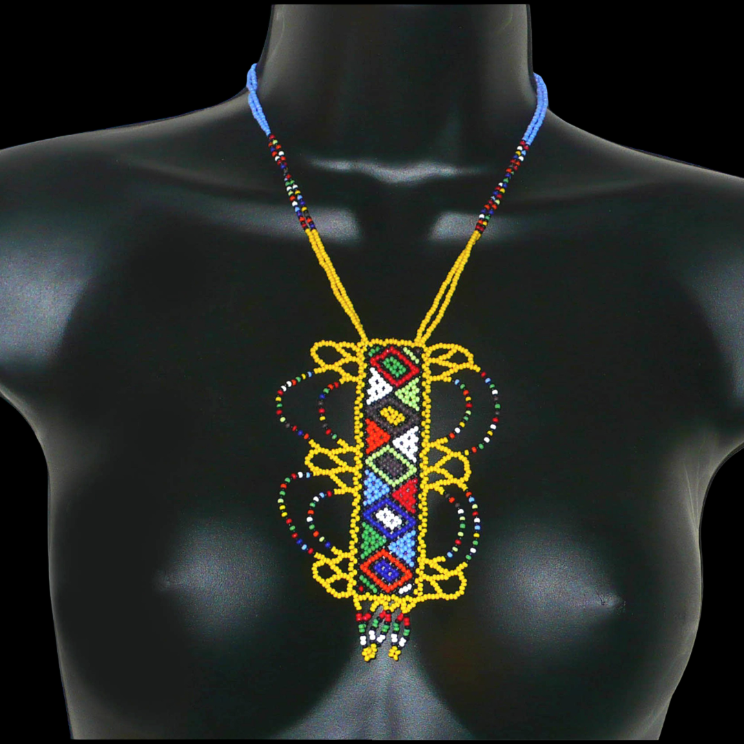 Collier sud-africain jaune orné d'un long pendentif fantaisie décoré de motifs ethniques zoulous multicolores ; il se compose de perles de rocaille et s'attache avec un fermoir à boule.