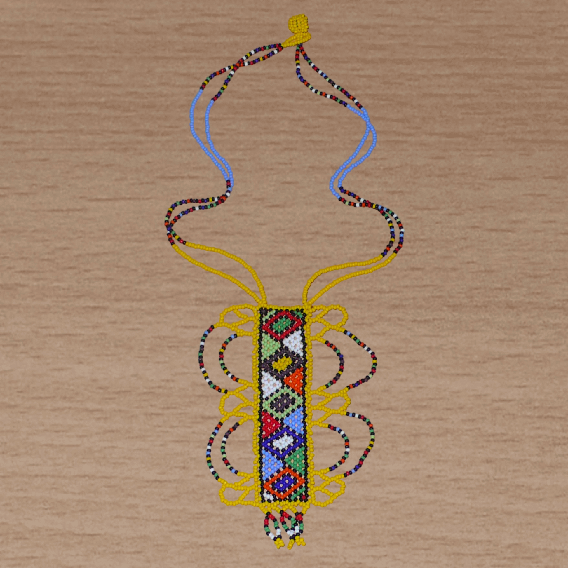 Collier sud-africain jaune orné d'un long pendentif fantaisie décoré de motifs ethniques zoulous multicolores ; il se compose de perles de rocaille et s'attache avec un fermoir à boule.