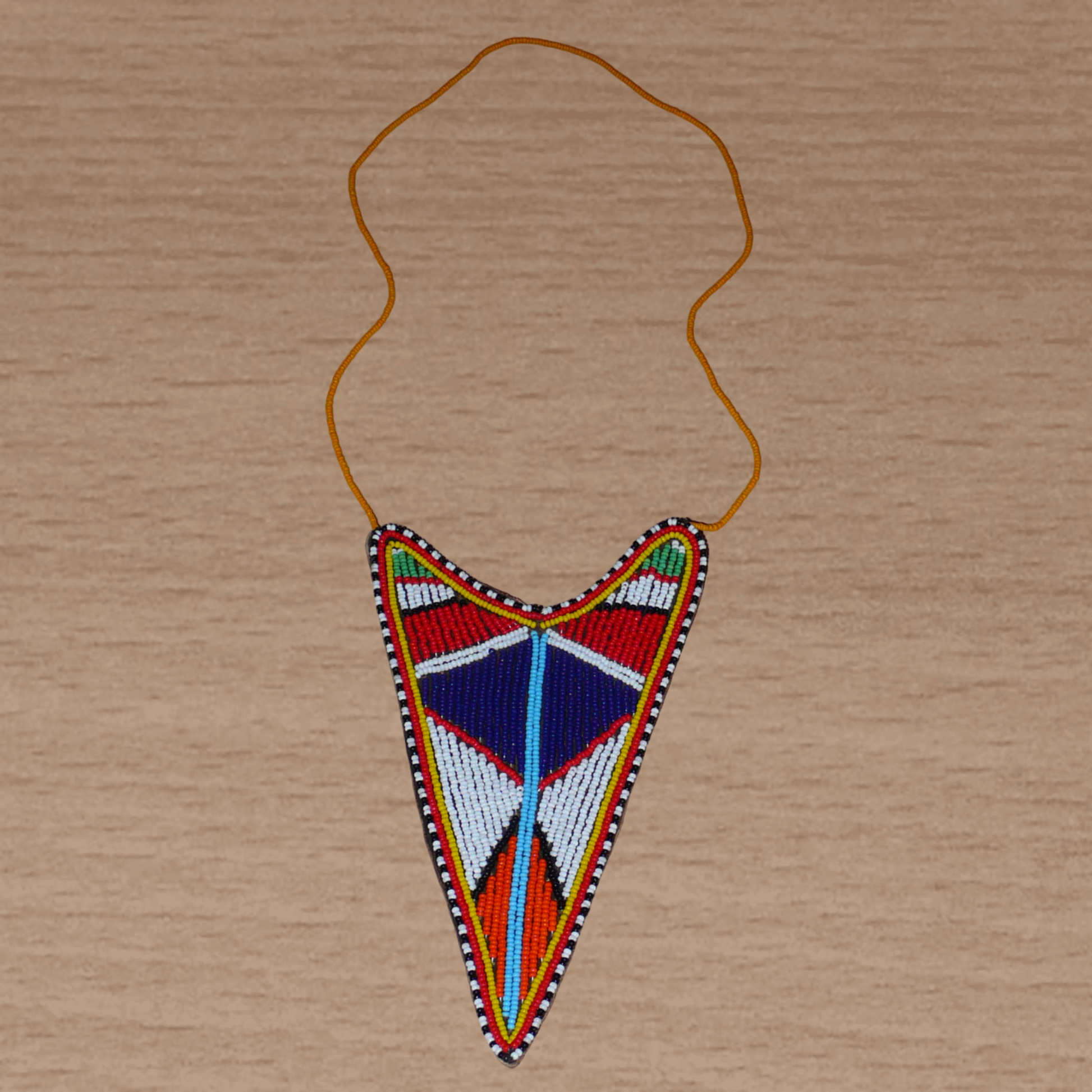 Long collier africain tribal de tradition Massai agrémenté d'un long et large pendentif aux couleurs et motifs ethniques composé d'une broderie de perles de rocaille multicolores.