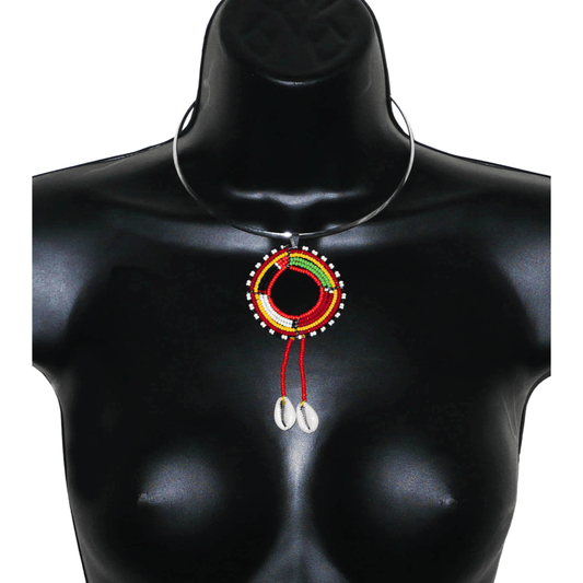 Bijou africain à l'allure exotique ; il se compose d'un ras de cou en laiton rehaussé d'un long pendentif perlé selon la tradition Massai fait de perles de rocaille rouges et multicolores et de coquillages cauris.