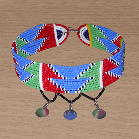 Collier africain ras de cou de tradition Massai composé de douze rangées de perles de rocaille rouges, bleues, vertes, blanches et noires et décoré de petits disques métalliques ; il se ferme avec un crochet.