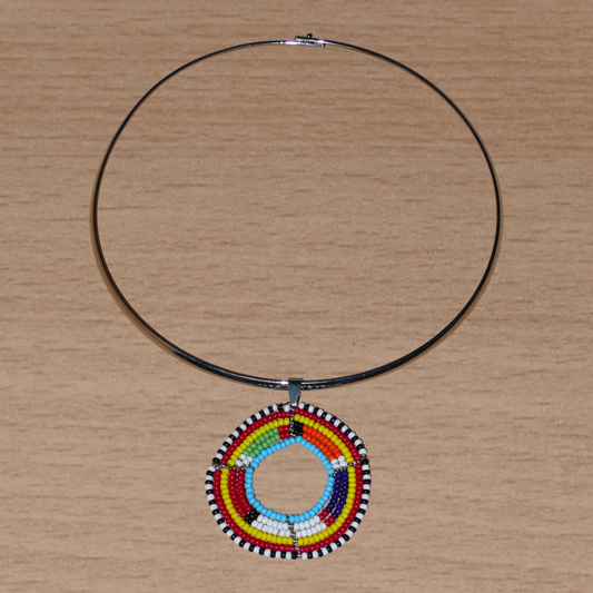 Collier africain ethnique composé d'un ras de cou en laiton agrémenté d'un médaillon traditionnel Massai fait de perles de rocaille multicolores.