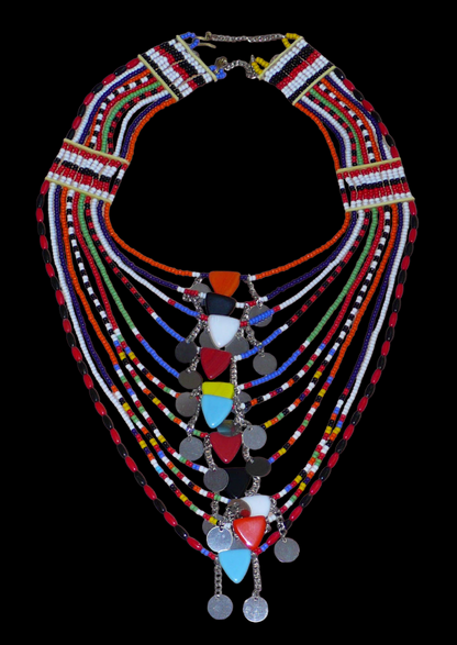 Collier africain traditionnel Massai composé de plusieurs rangées de perles multicolores ; des perles triangulaires et des pastilles en métal décorent le collier en son centre.
