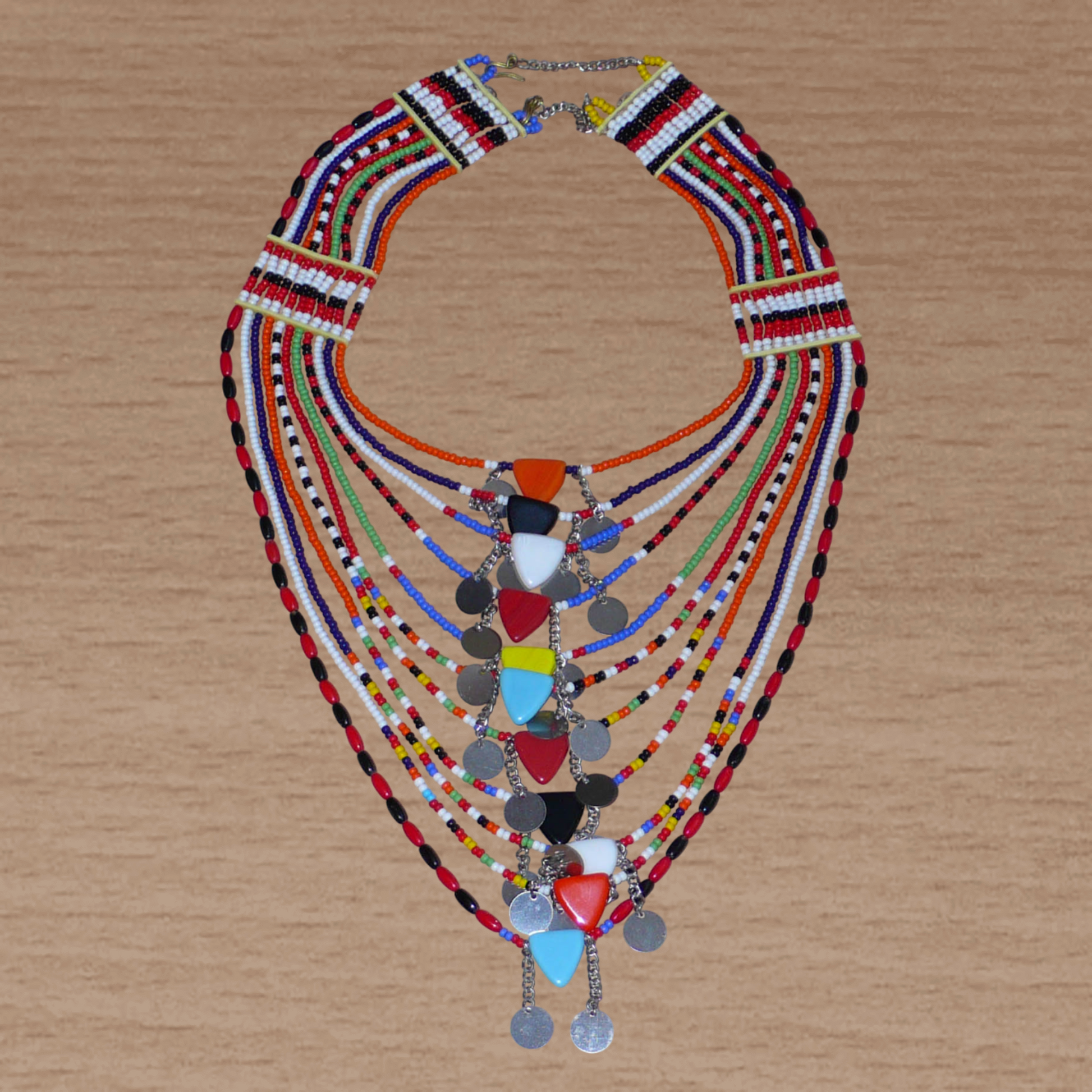 Collier africain traditionnel Massai composé de plusieurs rangées de perles multicolores ; des perles triangulaires et des pastilles en métal décorent le collier en son centre.