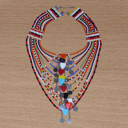 Collier africain traditionnel Massai composé de plusieurs rangées de perles multicolores ; des perles triangulaires et des pastilles en métal décorent le collier en son centre.