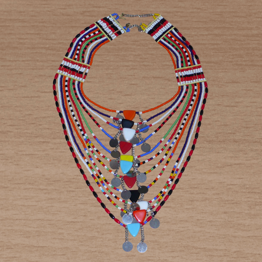 Collier africain traditionnel Massai composé de plusieurs rangées de perles multicolores ; des perles triangulaires et des pastilles en métal décorent le collier en son centre.