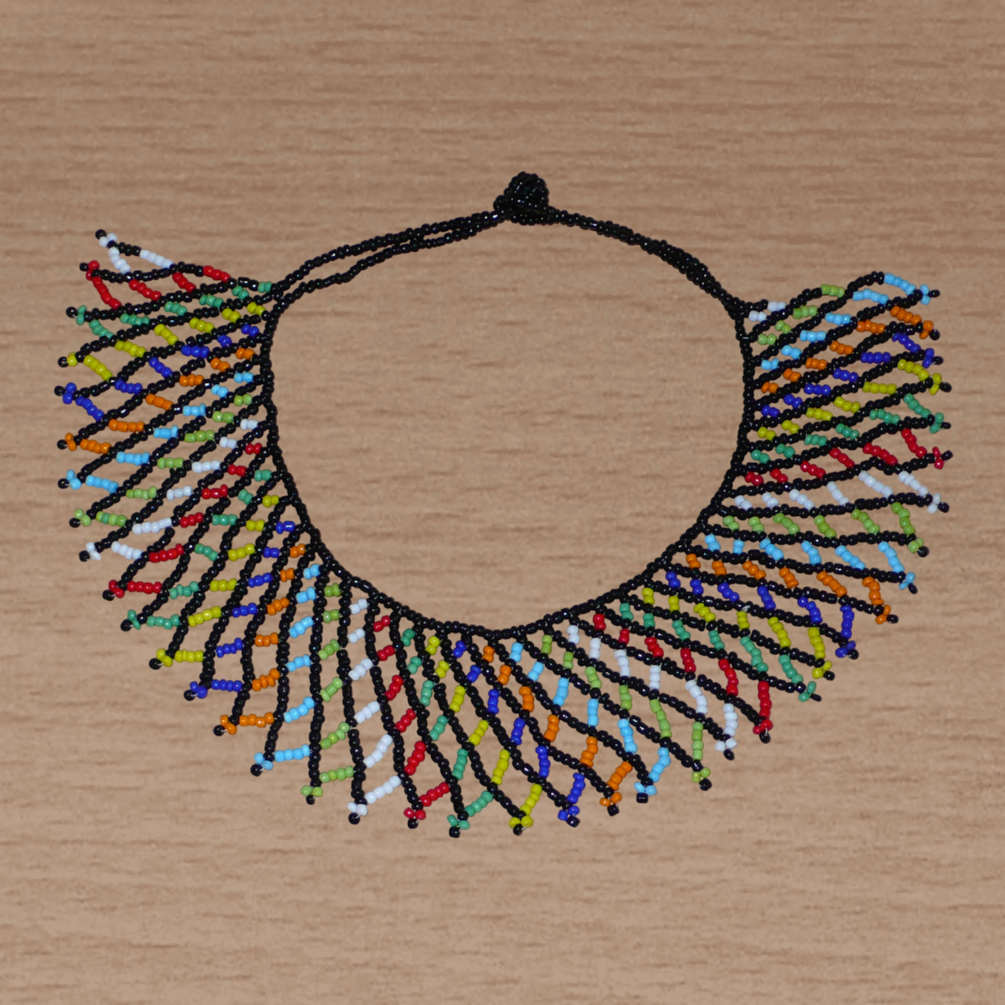 Collier africain zoulou traditionnel composé d'une dentelle de perles de rocaille noires et multicolores entrelacées.