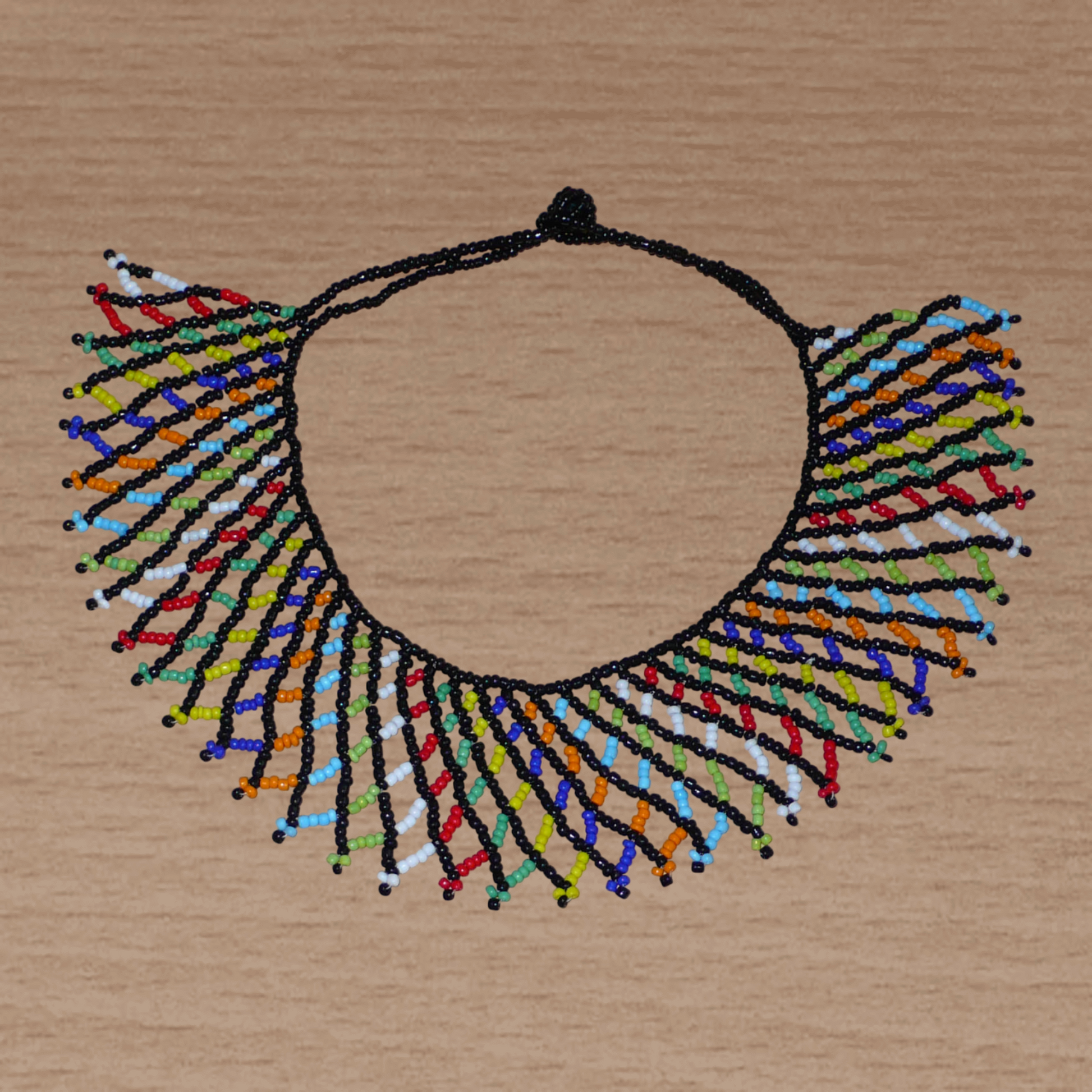 Collier africain zoulou traditionnel composé d'une dentelle de perles de rocaille noires et multicolores entrelacées.