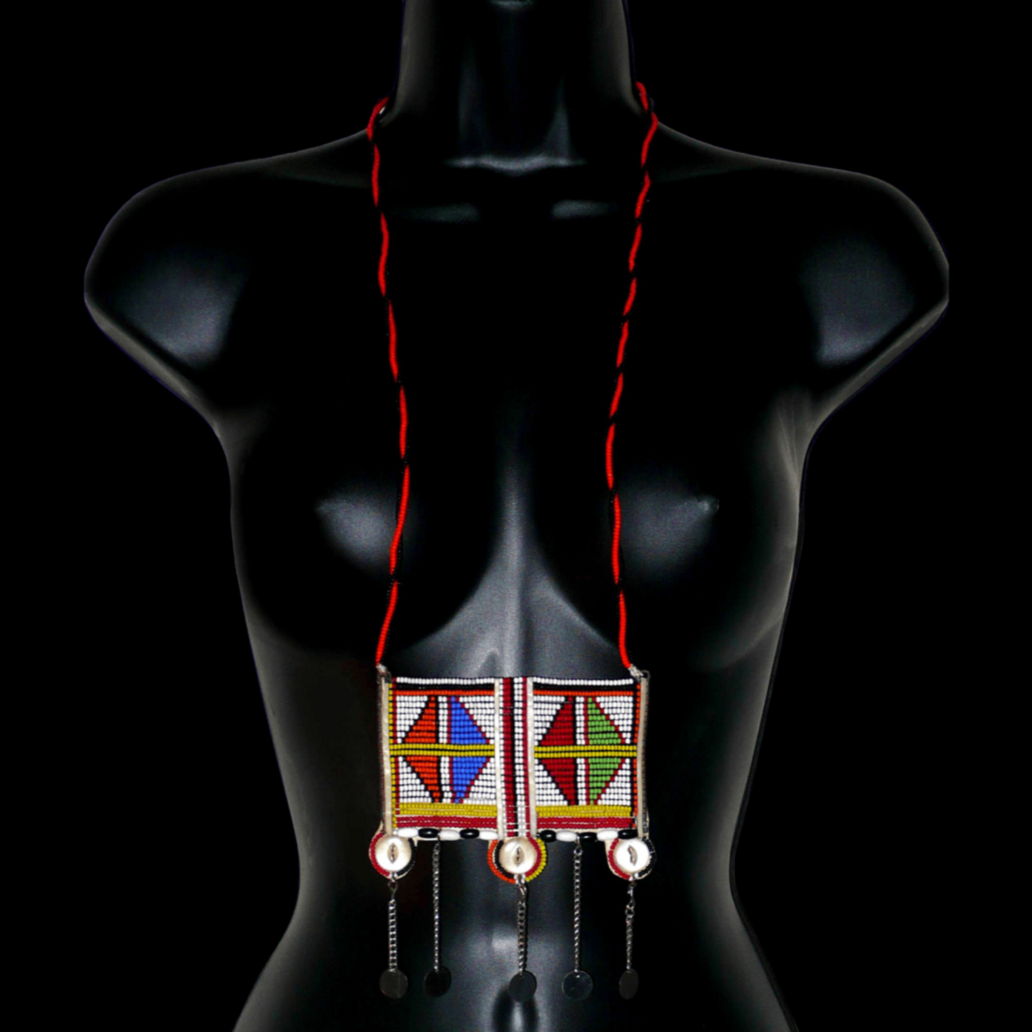 Long collier africain Massai traditionnel de style sautoir orné d'un large pendentif à motifs tribaux fait de perles brodées et de boutons nacrés ; il se prolonge de chaînettes décorées de pastilles métalliques.