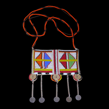 Long collier africain Massai traditionnel de style sautoir orné d'un large pendentif à motifs tribaux fait de perles brodées et de boutons nacrés ; il se prolonge de chaînettes décorées de pastilles métalliques.
