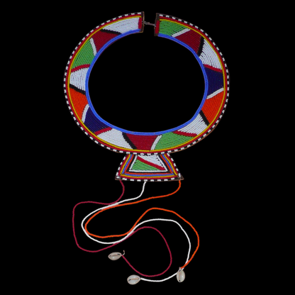 Collier africain traditionnel Massai composé de perles de rocaille multicolores brodées sur un morceau de cuir brut ; il se prolonge de longues franges faites de perles et de coquillages cauris.