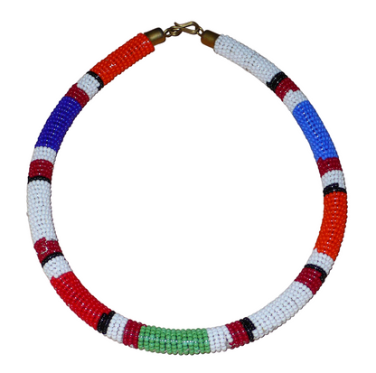 Bijou africain traditionnel. Collier africain tubulaire à motifs ethniques Massai fait de perles de rocaille bleues, blanches, bleues, vertes et rouges enroulées autour d'un tube en plastique. Il mesure 18 cm de long, sa longueur autour du cou est de 45 cm et son épaisseur de 1 cm ; il s'attache avec un crochet. Il est sur cette photo présenté sur un fond blanc. Timeless Fineries