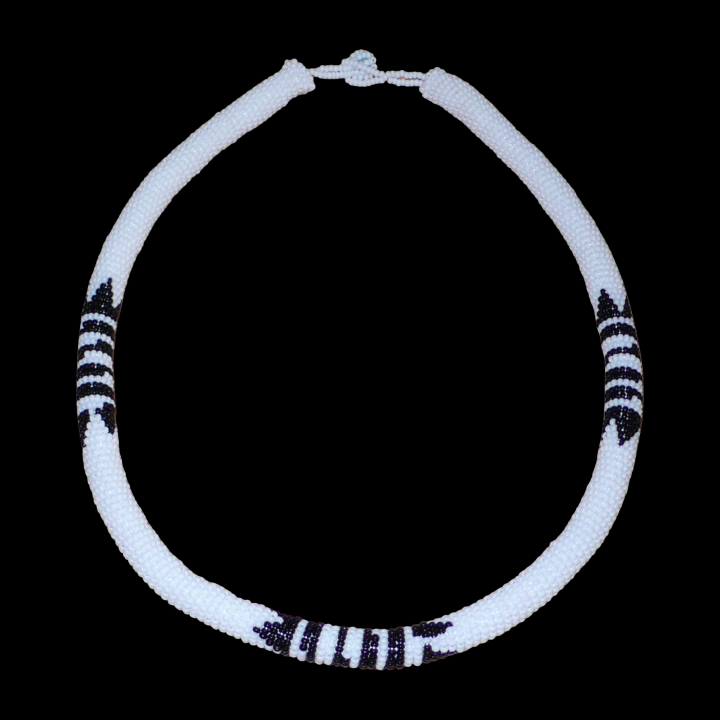 Collier africain zoulou blanc à motifs ethniques traditionnels noirs composé perles de rocaille tissées et enroulées autour d'un tube en plastique.