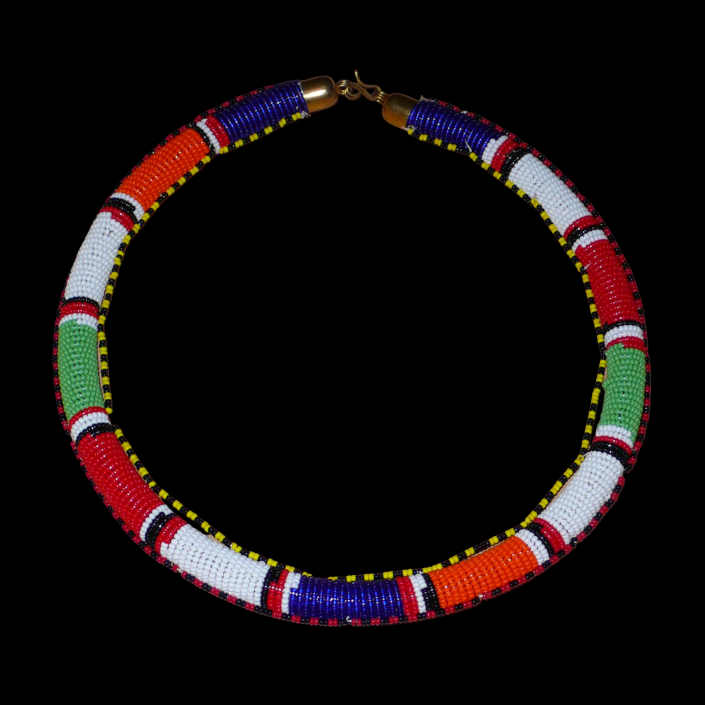 Collier africain tubulaire de tradition tribale Massai composé de perles de rocaille multicolores. Photographié sur un fond noir.