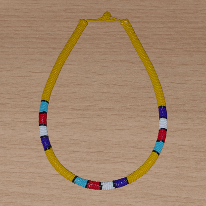 Collier africain tubulaire jaune à motifs ethniques traditionnels zoulous composé de perles de rocaille enroulées autour d'un tube en plastique.