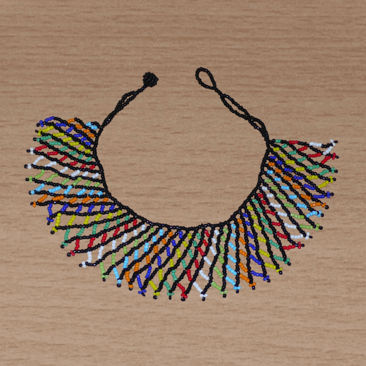 Collier sud-africain traditionnel zoulou composé d'une dentelle perlée faite de perles de rocaille noire et multicolores entrelacées.