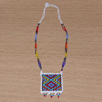 Collier africain zoulou en perles de rocaille blanches et multicolores agrémenté d'un pendentif carré à motifs ethniques traditionnels.