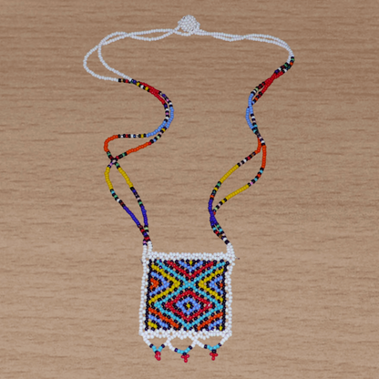 Collier africain zoulou en perles de rocaille blanches et multicolores agrémenté d'un pendentif carré à motifs ethniques traditionnels.