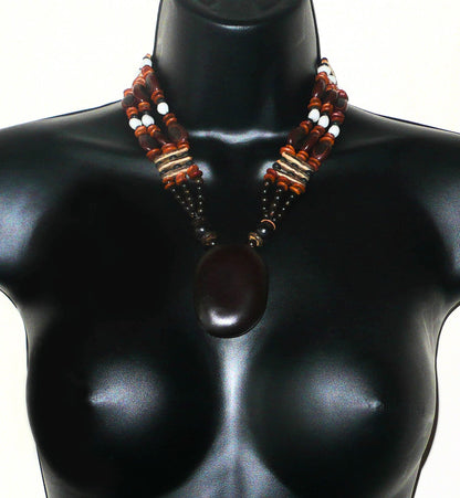 Collier afro-caribéen multi-rangs avec pendentif composé de perles de coco et d'un mélange de graines organiques (graine d'Entada (ou wawa), flamboyant, larmes de Job, toloman, "oreilles à mulâtres", savonnettes et casses).