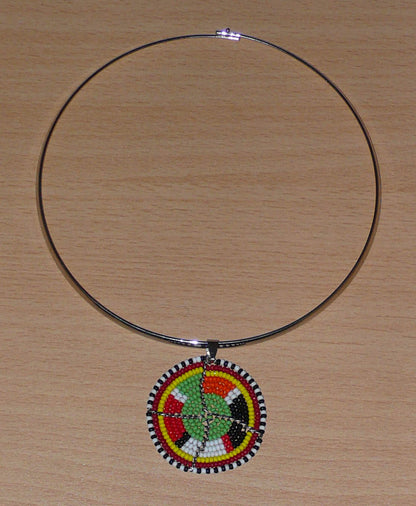 Bijou africain contemporain composé d'un collier ras de cou en laiton rehaussé d'un médaillon à motifs ethniques Massai fait d'un tissage de perles vertes et multicolores.