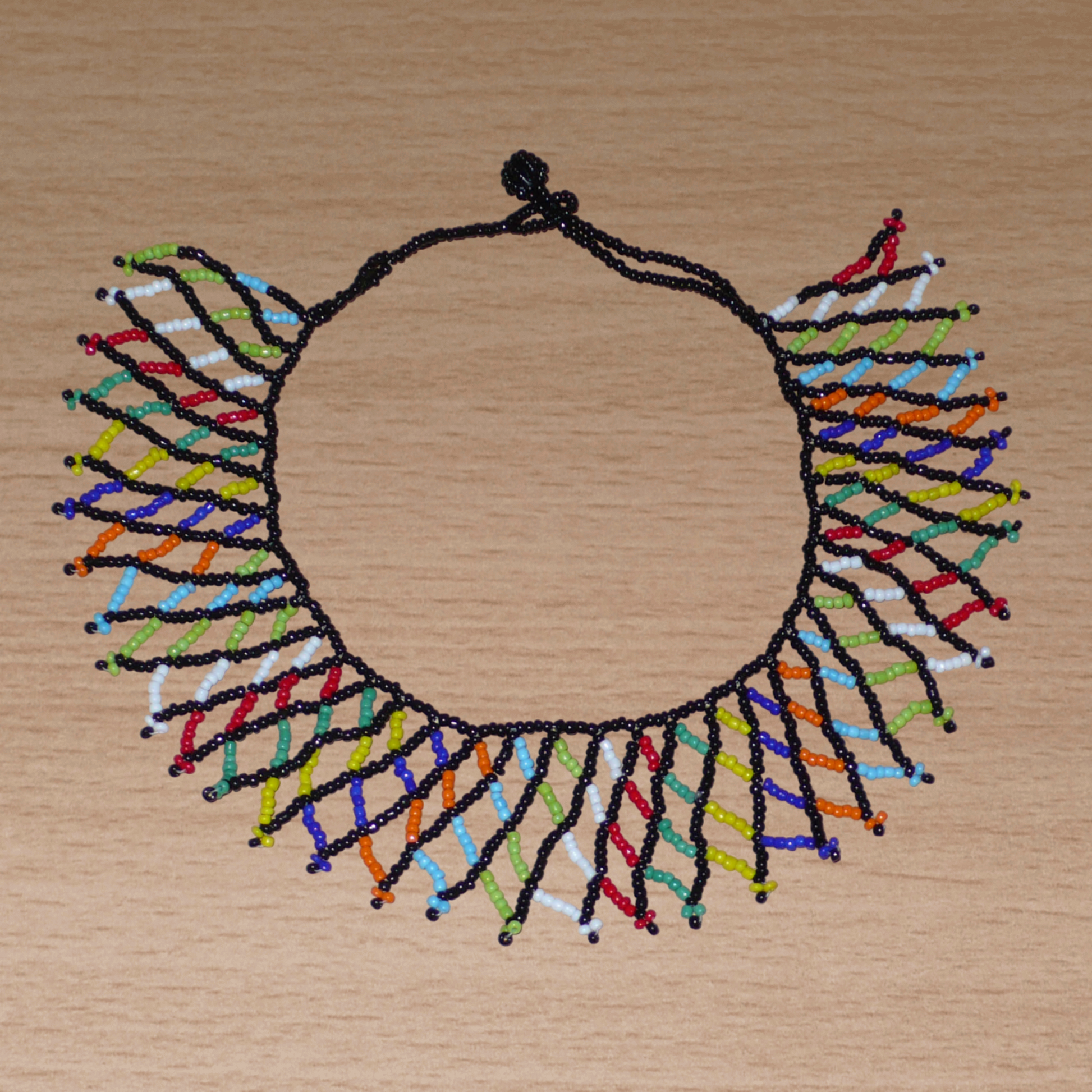 Collier africain traditionnel zoulou fabriqué en Afrique du Sud composé d'une dentelle de perles de rocaille noires et multicolores.