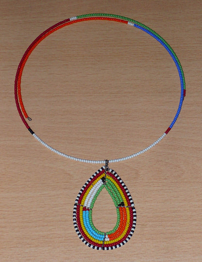 Collier ras de cou africain Massai orné d'un pendentif à motifs ethniques en forme de goutte fait de perles de rocaille colorées.