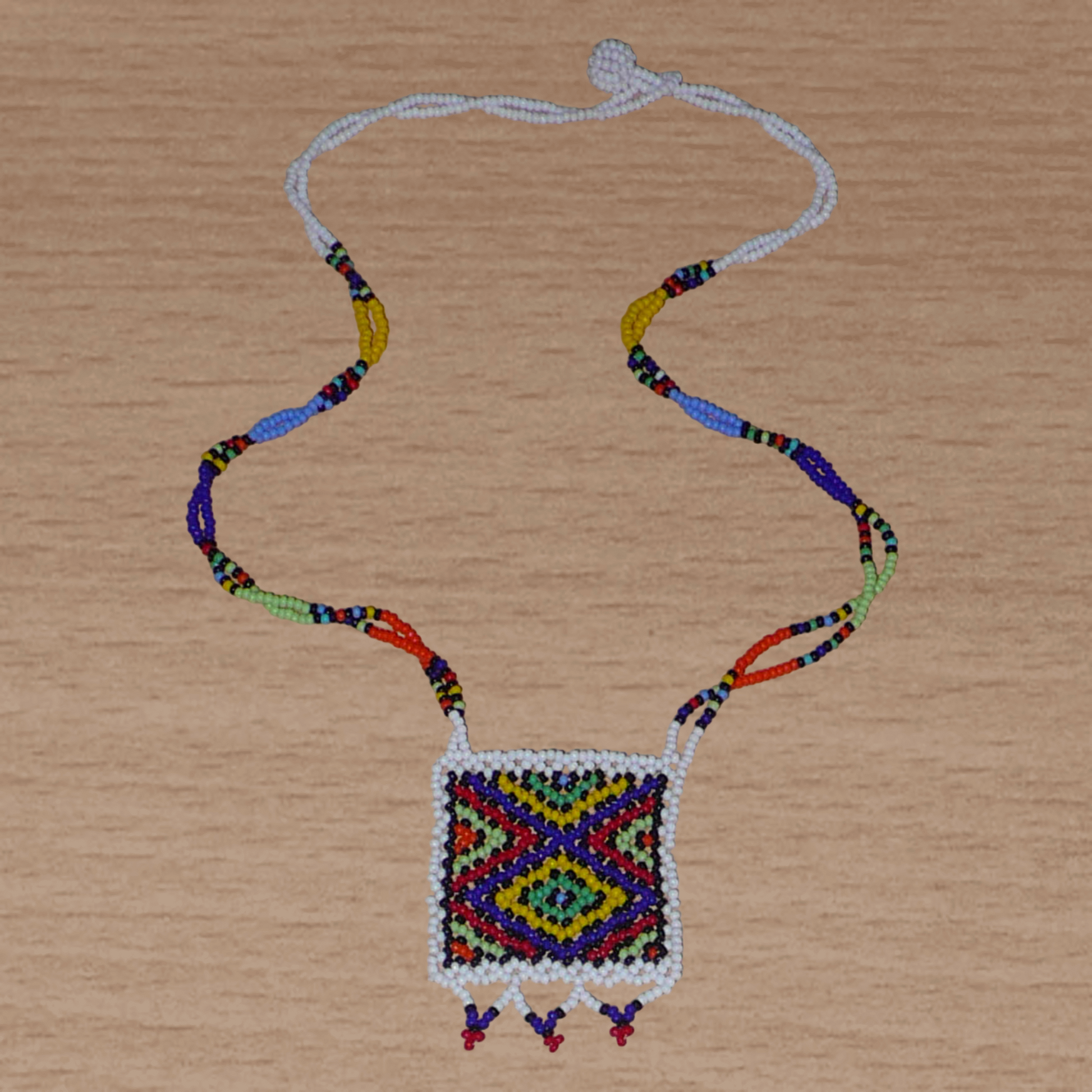 Collier africain zoulou avec pendentif ; fabriqué en Afrique du Sud, il se compose d'un tissage traditionnel de perles de rocaille blanches et multicolores.