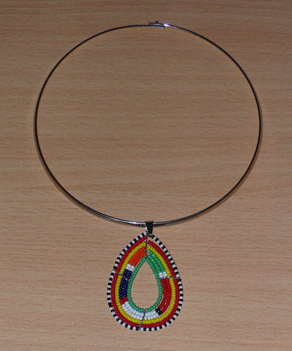 Collier africain composé d'un ras-de-cou en laiton agrémenté d'un pendentif aux couleurs et motifs Massai fait de perles de rocaille vertes et multicolores enfilées sur six rangées de fils de fer montés en forme de goutte.