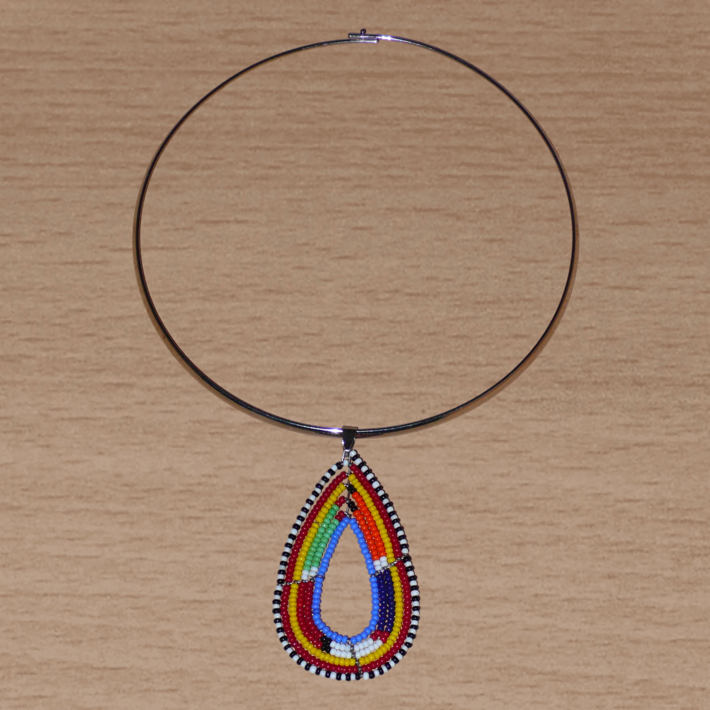 Collier ethnique chic composé d'un ras de cou en laiton orné d'un pendentif Massai en forme de goutte.