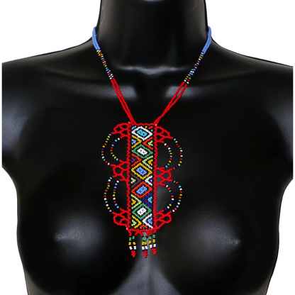 Collier sud-africain traditionnel rouge et multicolore agrémenté d'un long et large pendentif fantaisie en perles de rocaille.