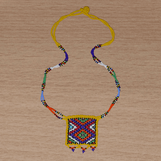 Collier africain Zoulou avec pendentif orné de motifs ethniques traditionnels. Il se compose de perles de rocaille jaunes et multicolores et s'attache avec un fermoir à boule.