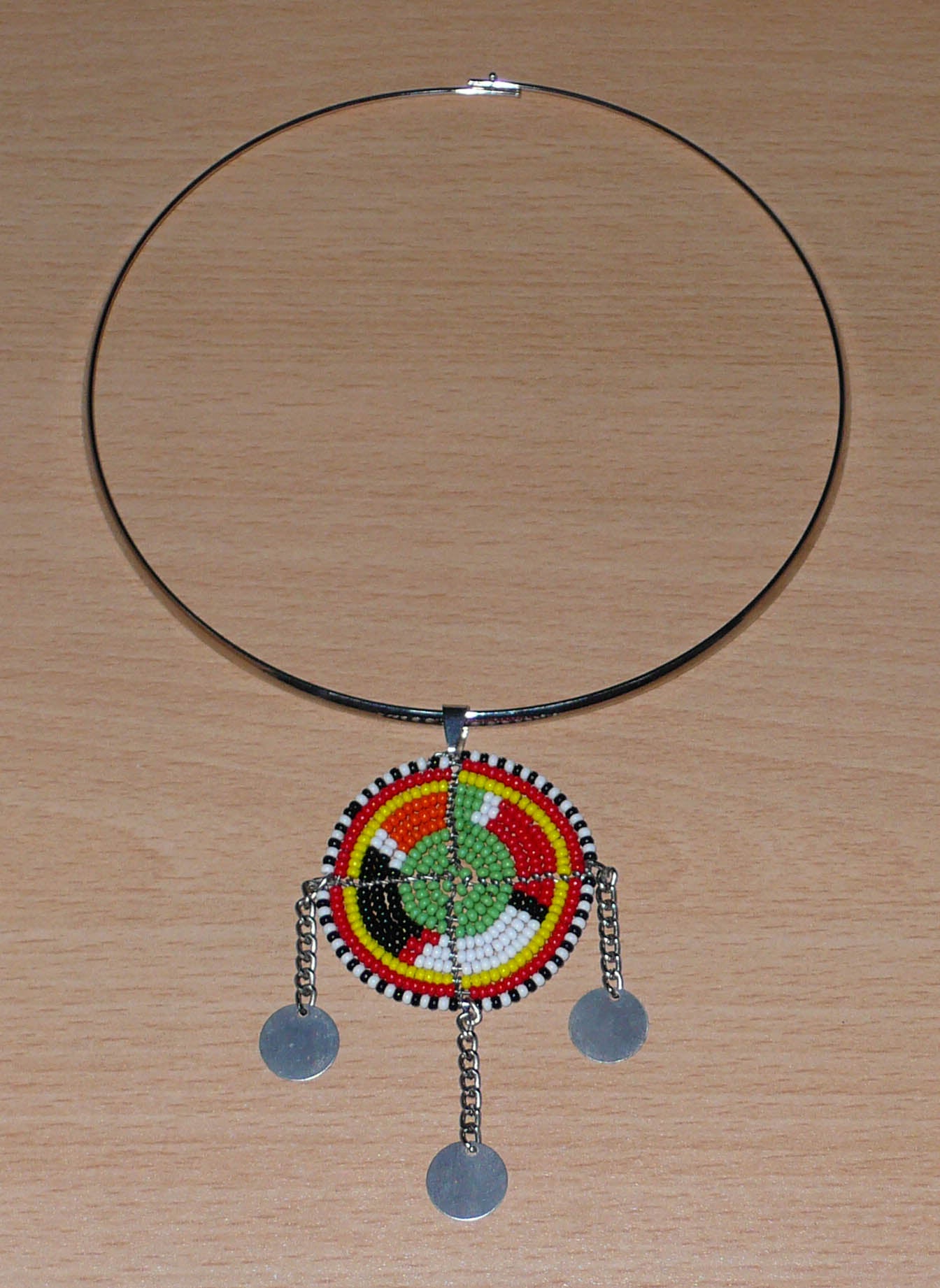 Collier africain Massai au style ethnique chic composé d'un ras de cou en laiton agrémenté d'un pendentif tribal vert et multicolore.
