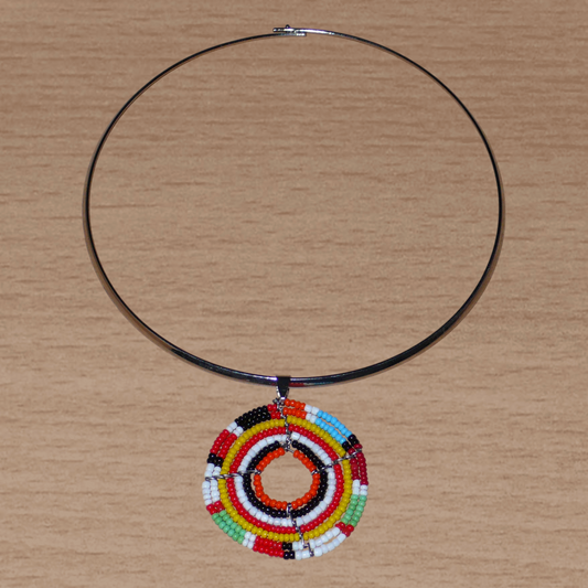Bijou ethnique coloré composé d'un ras de cou en laiton rehaussé d'un médaillon Massai fait de perles de rocaille multicolores.