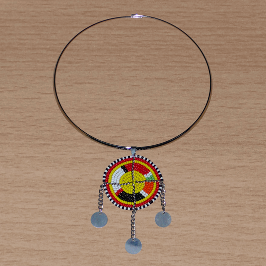 Collier ethnique chic composé d'un ras de cou en laiton rehaussé d'un pendentif Massai fait de perles de rocaille multicolores et de chaînettes décorées de disques métalliques.