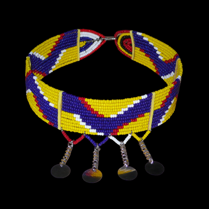 Collier multi-rangs africain Massai à motifs ethniques composé de douze rangées de perles de rocaille jaunes, bleu foncé, rouges et blanches et prolongé de chaînettes décorées de pastilles métalliques ; il se ferme avec un crochet.