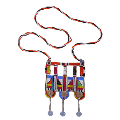 Authentique bijou africain Massai, ce long collier de style sautoir est orné d'un large pendentif à motifs ethniques fait de perles de rocaille multicolores et de boutons nacrés brodés sur un morceau de plastique recyclé ; ils se prolonge de chaînettes décorées de pastilles métalliques.