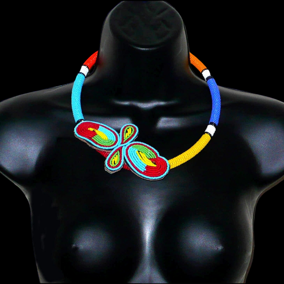 Collier sud-africain tubulaire composé de perles de rocaille multicolores et décoré à sa base d'un papillon brodé sur un morceau de cuir.