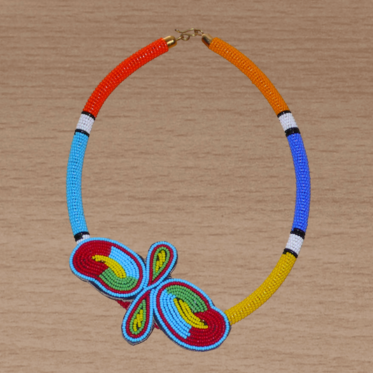 Collier sud-africain tubulaire composé de perles de rocaille multicolores et décoré à sa base d'un papillon brodé sur un morceau de cuir.